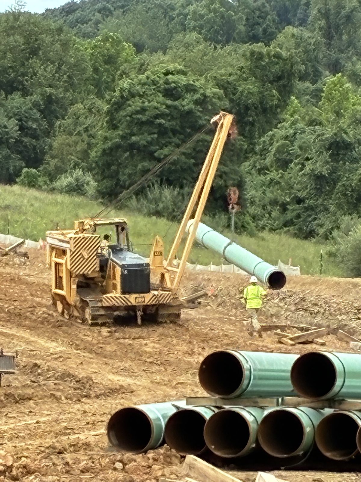 LiUNA member guiding pipe into place with a sideboom